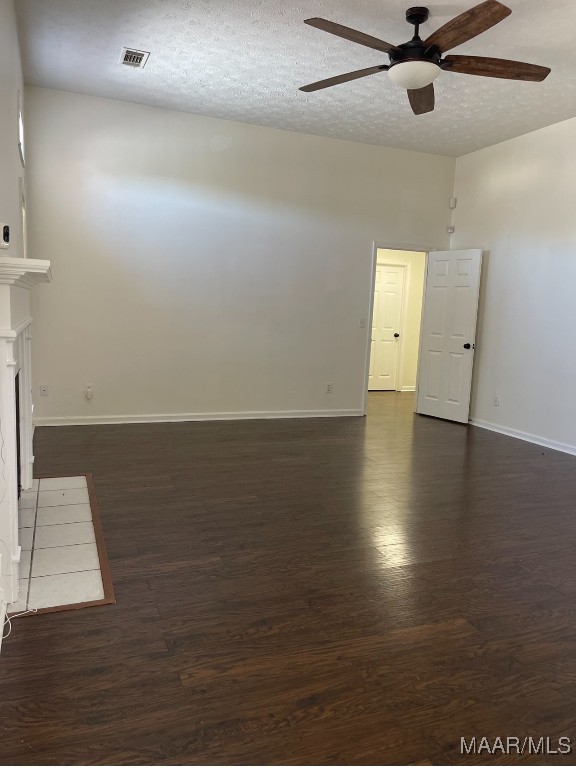 unfurnished room featuring ceiling fan, a textured ceiling, and dark hardwood / wood-style flooring