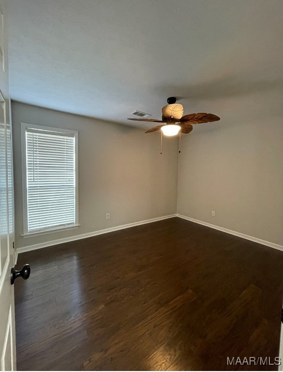 spare room with dark hardwood / wood-style floors and ceiling fan