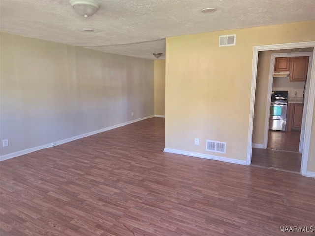 spare room with dark hardwood / wood-style flooring and a textured ceiling