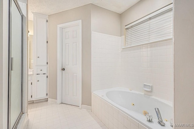 bathroom featuring tile patterned floors, shower with separate bathtub, and a textured ceiling