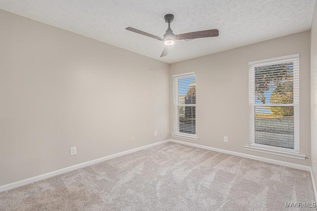 carpeted spare room featuring ceiling fan and a textured ceiling