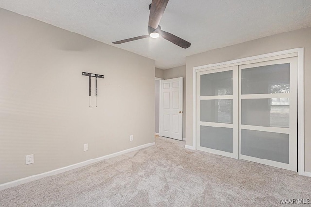 unfurnished room with ceiling fan, light carpet, and a textured ceiling