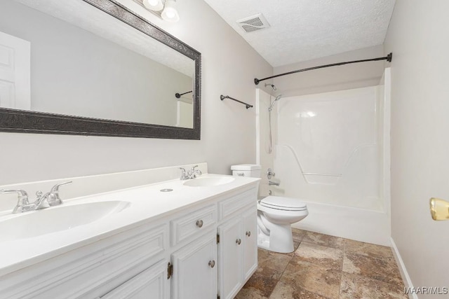 full bathroom with vanity, washtub / shower combination, a textured ceiling, and toilet