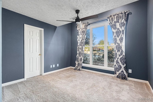 carpeted spare room featuring ceiling fan and a textured ceiling