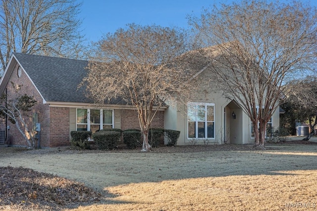 view of front of house with central air condition unit and a front lawn