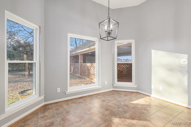 unfurnished dining area with a high ceiling and a chandelier