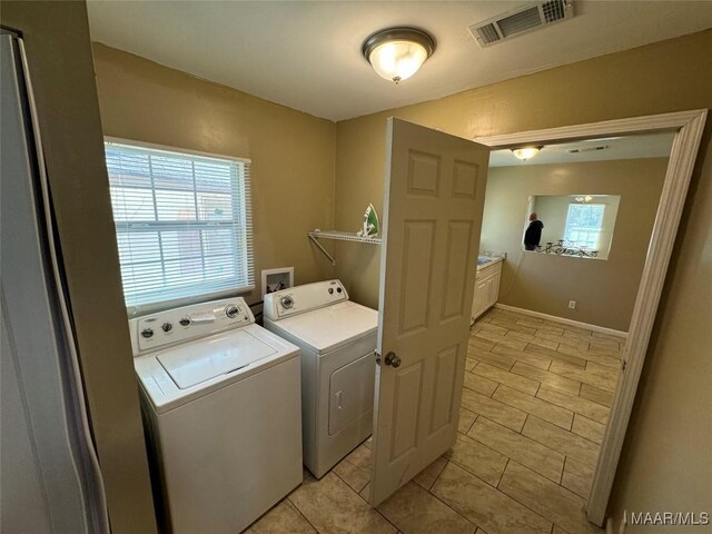 washroom with independent washer and dryer and light tile patterned floors