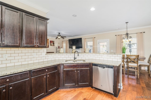 kitchen featuring decorative backsplash, stainless steel dishwasher, light wood-type flooring, decorative light fixtures, and sink