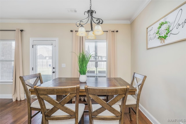 dining space featuring a wealth of natural light, ornamental molding, a notable chandelier, and dark hardwood / wood-style floors