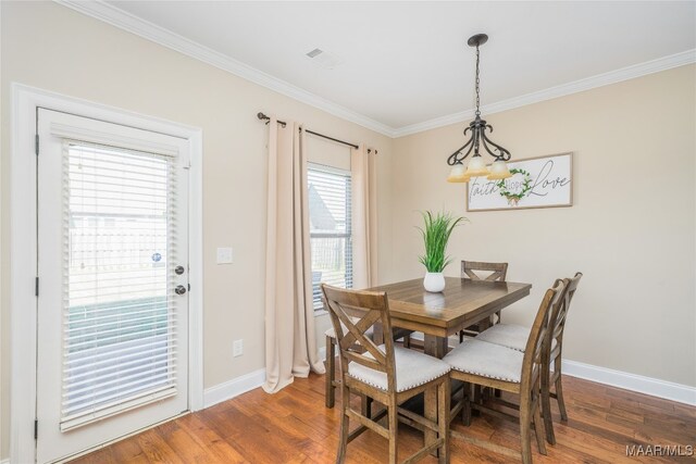 dining area with ornamental molding and dark hardwood / wood-style flooring