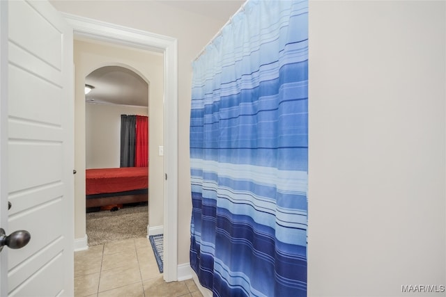 bathroom featuring walk in shower and tile patterned flooring