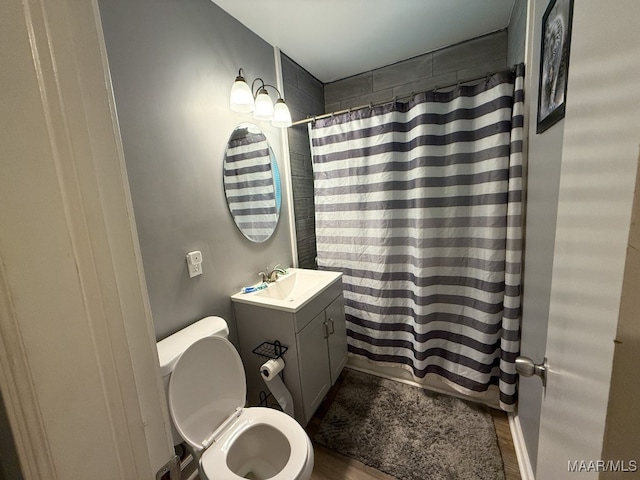 bathroom with toilet, a shower with curtain, vanity, and wood-type flooring