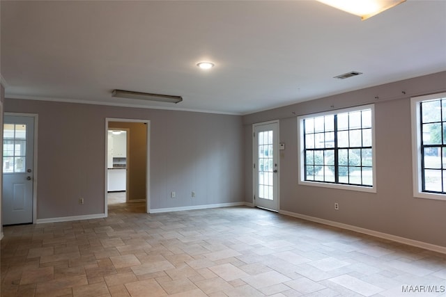 unfurnished room featuring ornamental molding and a healthy amount of sunlight