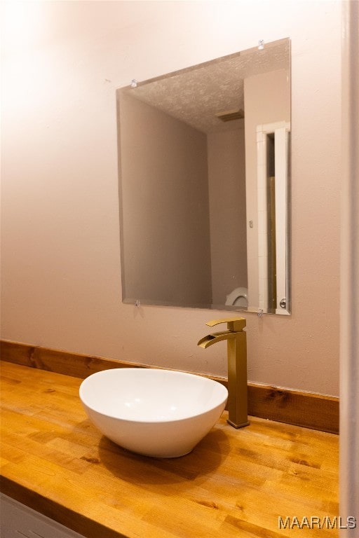 bathroom featuring sink, a textured ceiling, and hardwood / wood-style flooring