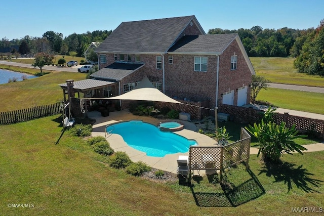 view of swimming pool with a patio area, a yard, and an in ground hot tub