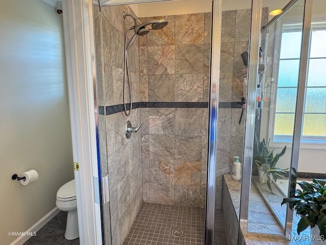 full bathroom featuring baseboards, a shower stall, and toilet