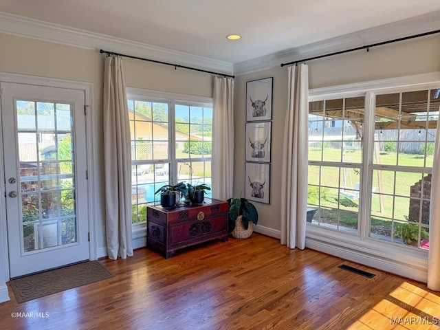 doorway featuring hardwood / wood-style floors and ornamental molding