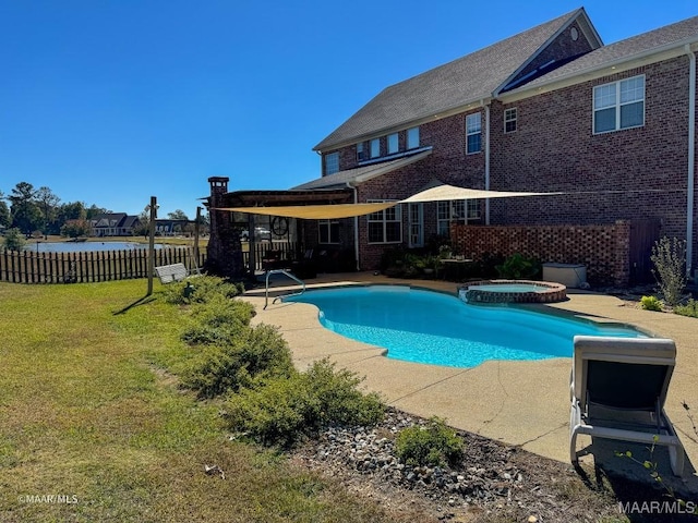 view of pool with a patio, fence, a pool with connected hot tub, and a lawn