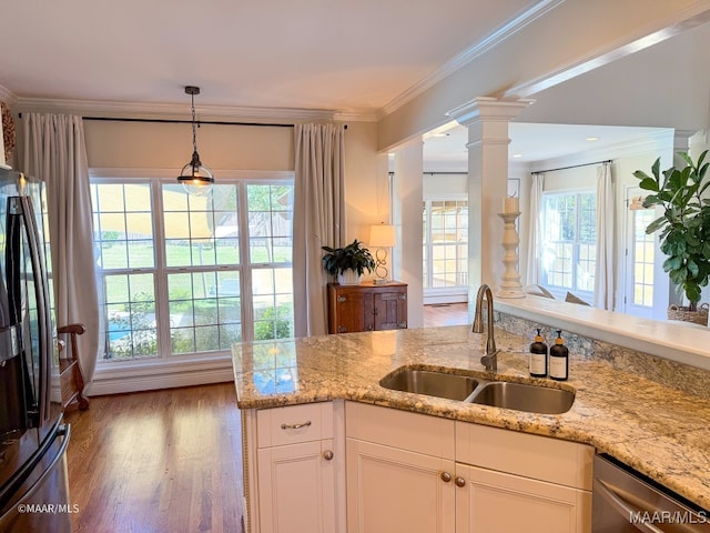 kitchen featuring ornate columns, white cabinetry, sink, crown molding, and appliances with stainless steel finishes