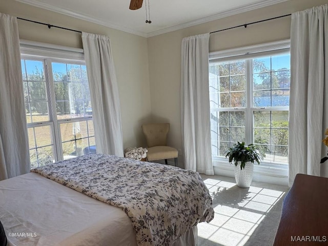 bedroom with ceiling fan, ornamental molding, and carpet floors