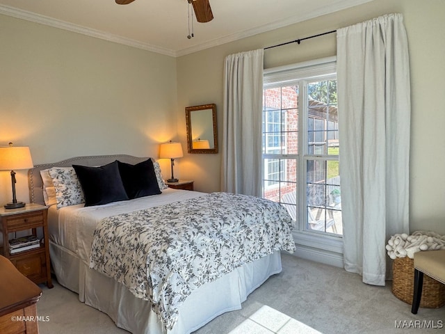 carpeted bedroom with ceiling fan and ornamental molding