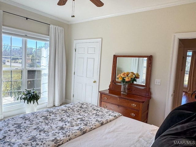 bedroom featuring ornamental molding, multiple windows, ceiling fan, and baseboards