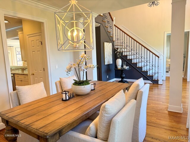 dining area featuring a chandelier, ornamental molding, and hardwood / wood-style flooring