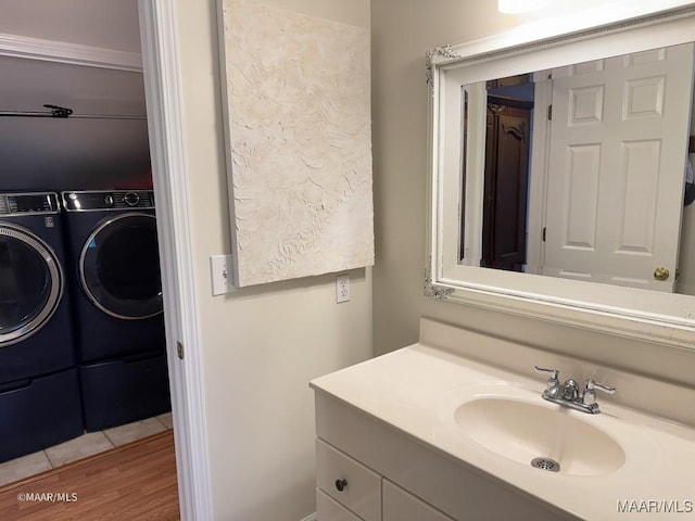 bathroom featuring wood-type flooring, vanity, and washer and clothes dryer