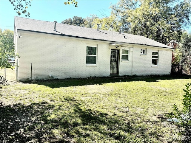 rear view of property featuring a yard