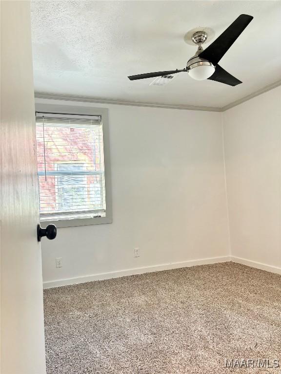 carpeted empty room with ceiling fan, a textured ceiling, and ornamental molding