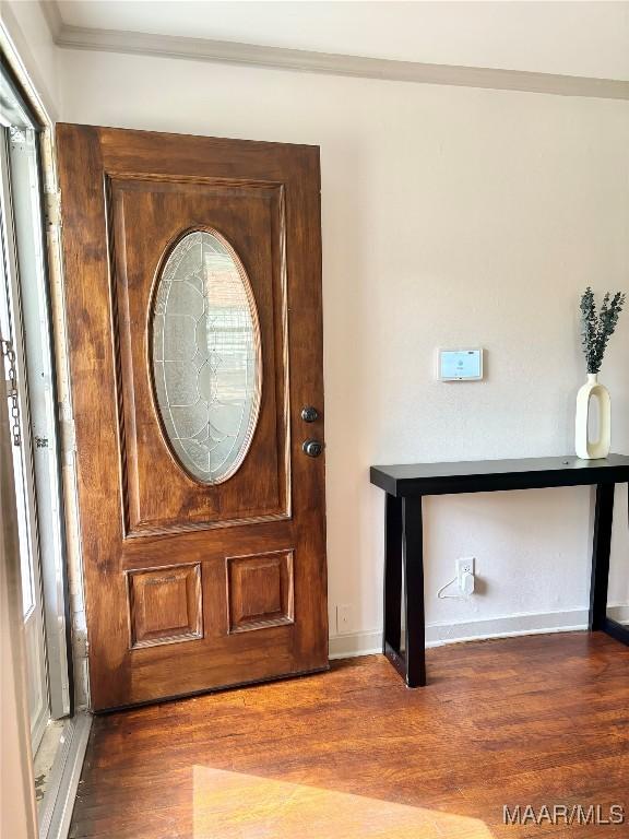 entrance foyer with dark hardwood / wood-style flooring and ornamental molding