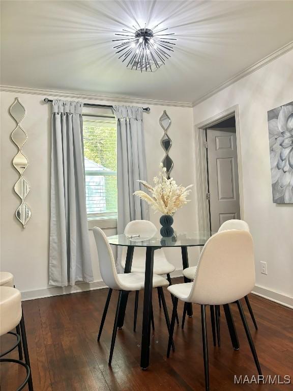 dining room featuring dark hardwood / wood-style flooring, crown molding, and a notable chandelier