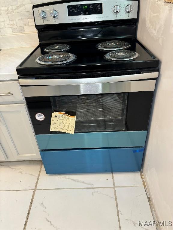 room details featuring white cabinets and electric range