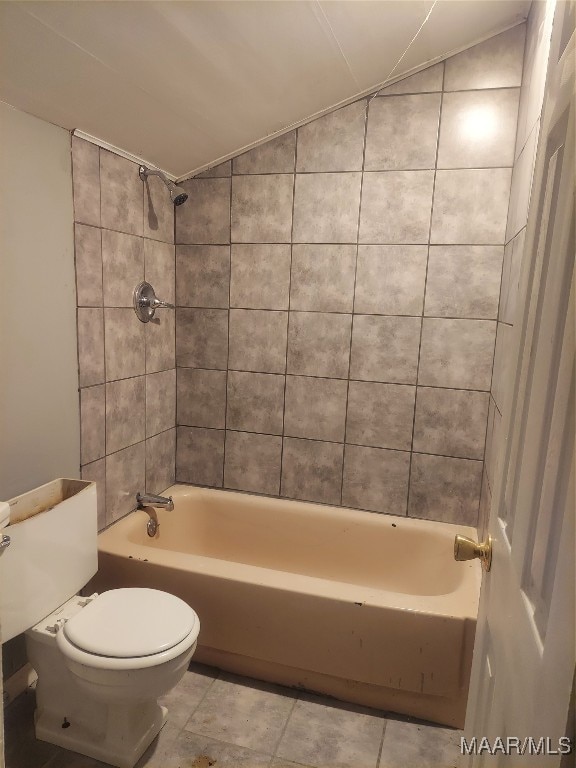 bathroom featuring toilet, tiled shower / bath combo, and lofted ceiling