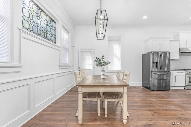 dining area featuring ornamental molding and dark hardwood / wood-style flooring