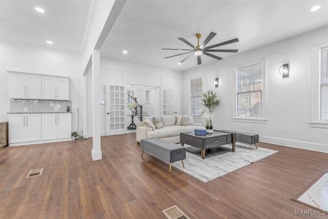 living room featuring a ceiling fan, wood finished floors, visible vents, and recessed lighting