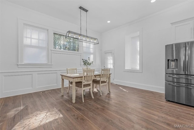 dining space with wood finished floors, recessed lighting, and crown molding