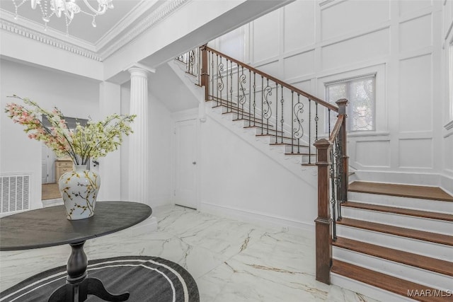 stairway with marble finish floor, a decorative wall, visible vents, and an inviting chandelier