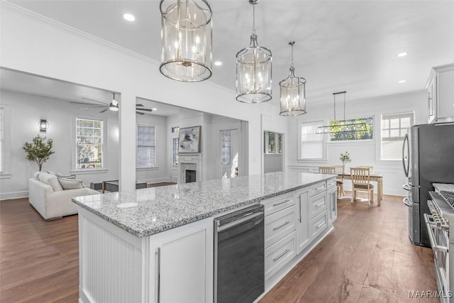 kitchen featuring light stone countertops, open floor plan, stainless steel appliances, and dark wood finished floors