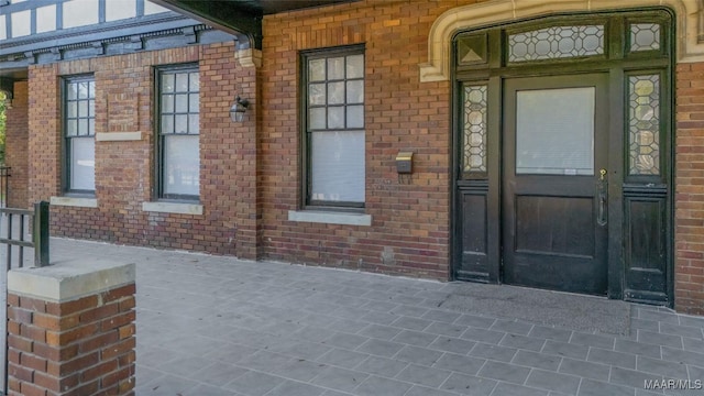 doorway to property with brick siding
