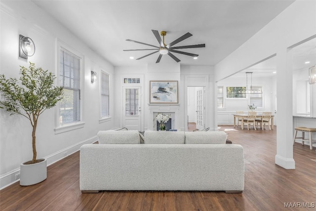 living area with ceiling fan, a fireplace, baseboards, dark wood-style flooring, and recessed lighting