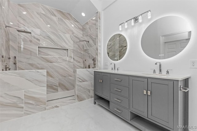 bathroom featuring double vanity, walk in shower, marble finish floor, and a sink