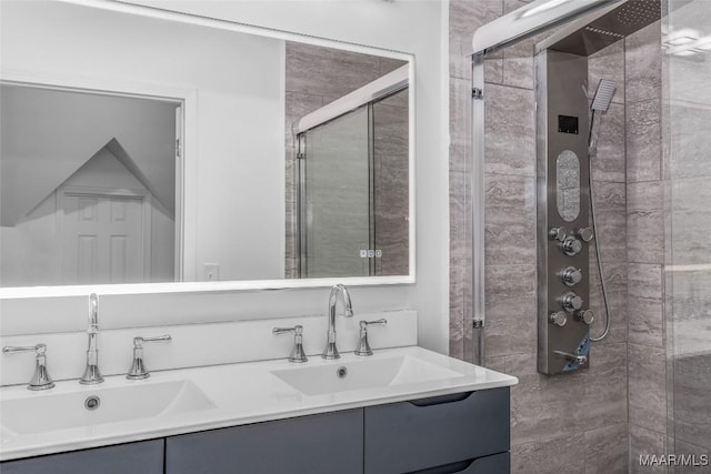 full bathroom with double vanity, a shower stall, and a sink