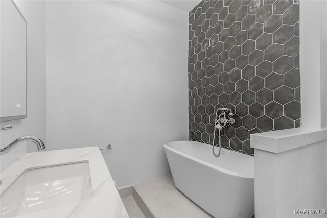 full bathroom featuring a soaking tub and a sink