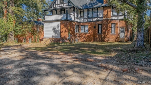 back of property with a chimney, brick siding, and entry steps