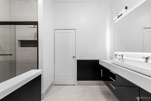 bathroom featuring vanity and a shower with door