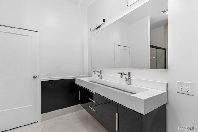 bathroom featuring a shower with door, visible vents, a sink, and double vanity