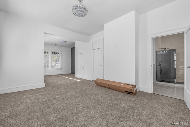 empty room with baseboards and carpet flooring