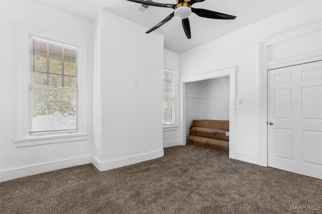 unfurnished bedroom with dark colored carpet, visible vents, a ceiling fan, and baseboards