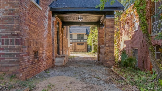 entrance to property featuring driveway and brick siding